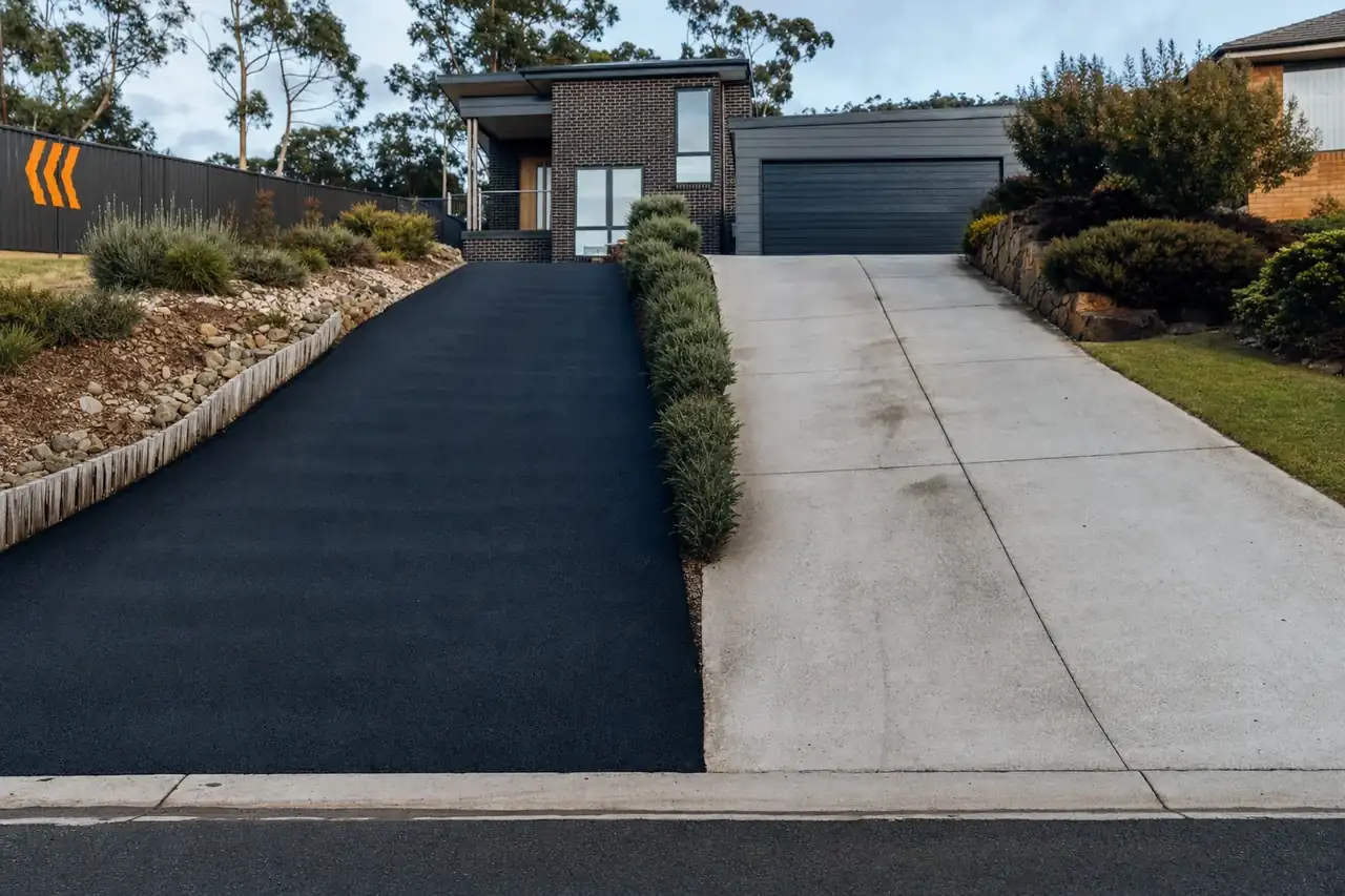 Side-by-side view of an asphalt driveway and a concrete driveway at Hobart residential properties